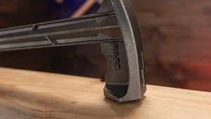 Blue Collar Steel Hammer's Hex Face Head hammering a nail on a piece of wood